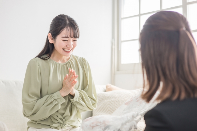 骨格診断やパーソナルカラー診断を受けてみて自分のタイプが分かり喜ぶ様子の若い女性